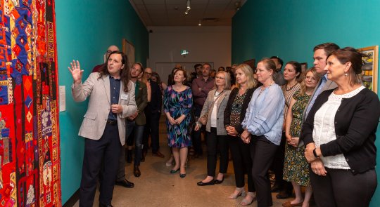 A group stands in a hallway looking at art