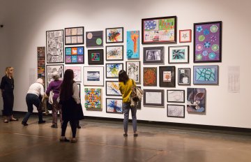 people admiring the artwork of the exhibition