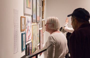 people admiring the artwork of the exhibition