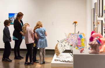 people admiring a sculpture on the floor of the art gallery