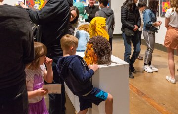 boy admiring a sculpture on a pedestal in the art gallery