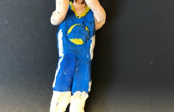 sculpture of a person playing basketball holding the ball in front of their face