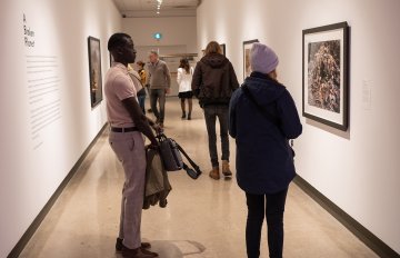 Corridor view of people viewing a Burtynsky framed photo