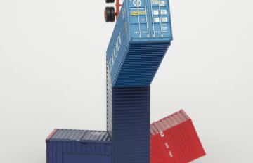 Blue and red colored HO scale model parts of a toy truck merged with shipping containers