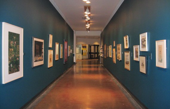 exhibition photo of long corridor with pictures on walls on either side