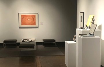 sitting area with books on display and an orange picture on the wall