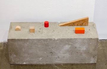 a cement block with various shapes on top of it